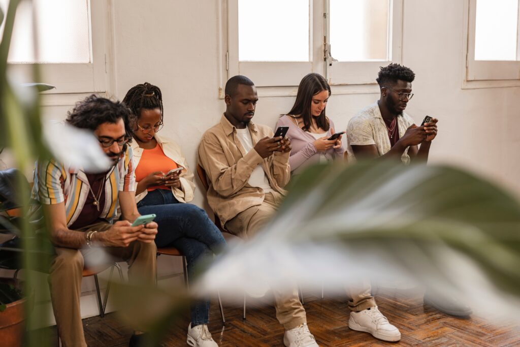 Group of adults on their phones asking what is tech addiction.