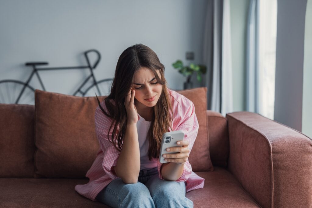 young adult sitting on phone frustrated how to break tech addiction​